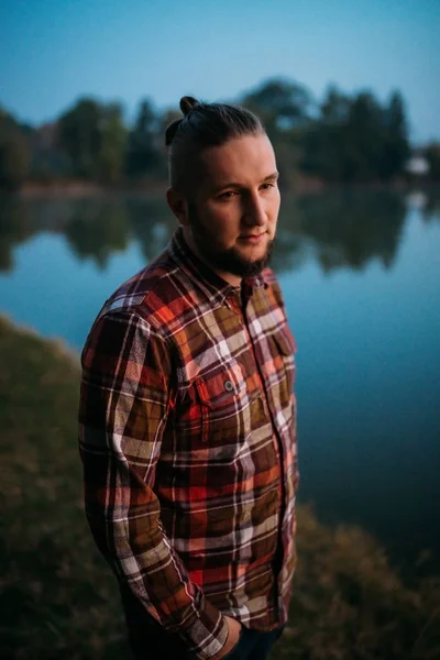 Portrait of a young guy with a beard in nature.