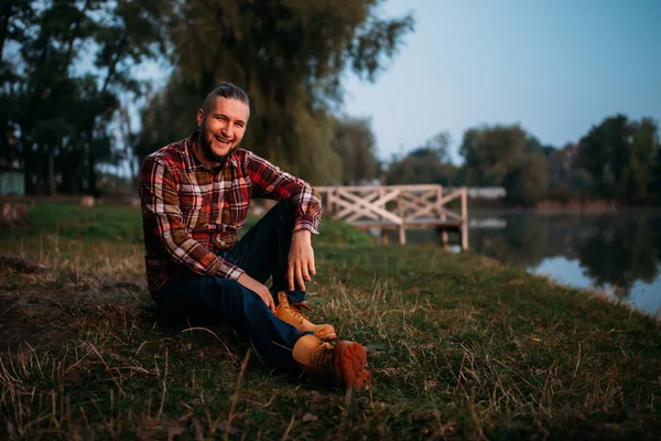 Portrait of a young guy with a beard in nature.