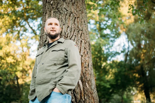 Portrait of a young guy with a beard in nature.