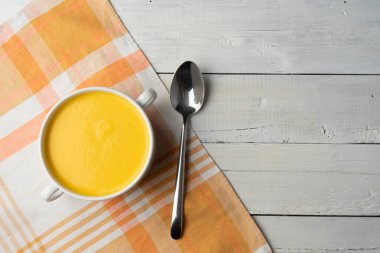 Tahta bir masada kremalı balkabağı çorbası