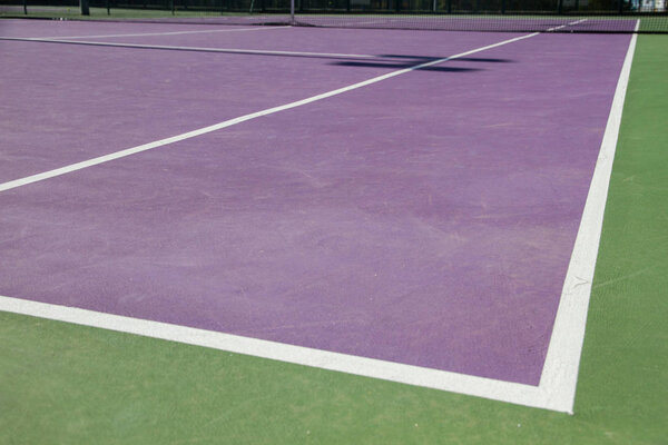 Lines of the corners of a cement tennis court. Track colors are purple and green. 