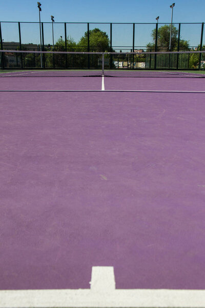 Lines of the center of a cement tennis court. Track colors are purple and green. 