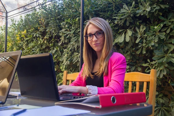 Jeune fille entreprenante travaillant avec ordinateur portable sur la terrasse de sa maison . — Photo