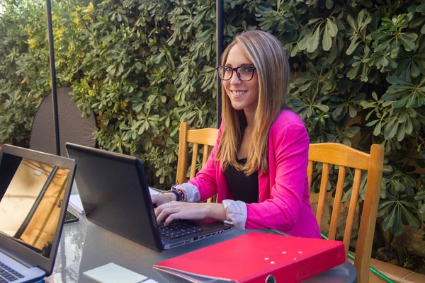 Jeune fille entreprenante travaillant avec ordinateur portable sur la terrasse de sa maison . — Photo