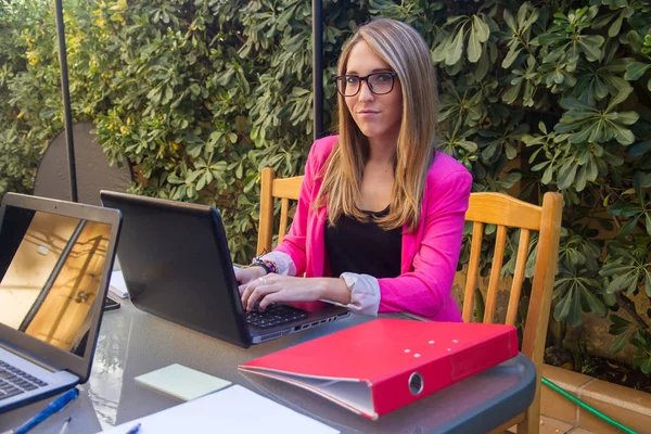 Joven chica emprendedora trabajando con el ordenador portátil en la terraza de su casa . —  Fotos de Stock