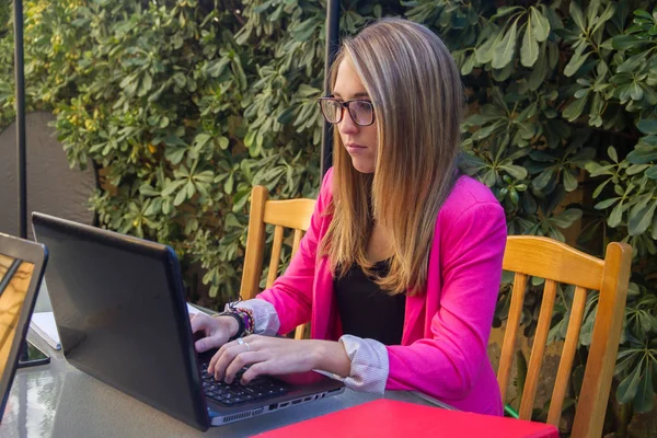 Jeune fille entreprenante travaillant avec ordinateur portable sur la terrasse de sa maison . — Photo