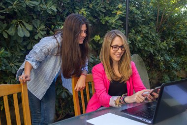 Genç Girişimciler ile bir dizüstü bilgisayar çalışma. Onların şirket oluşturmakta olduğunuz iki güzel beyaz kız olduklarını.