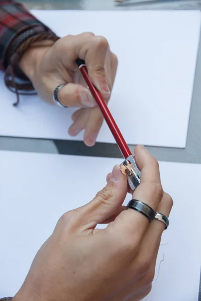 Photo of close up of a hands pulling a pencil point to continue writing on a table. — Stock Photo, Image