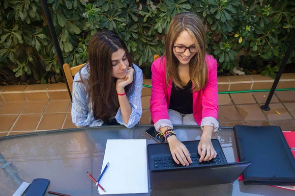 使用笔记本电脑的年轻企业家。他们有两个美丽的白人女孩正在创建自己的公司. — 图库照片