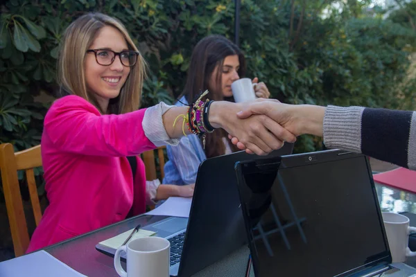 Young businesswomen shaking hands. They are greeted before they start working together. — Stock Photo, Image