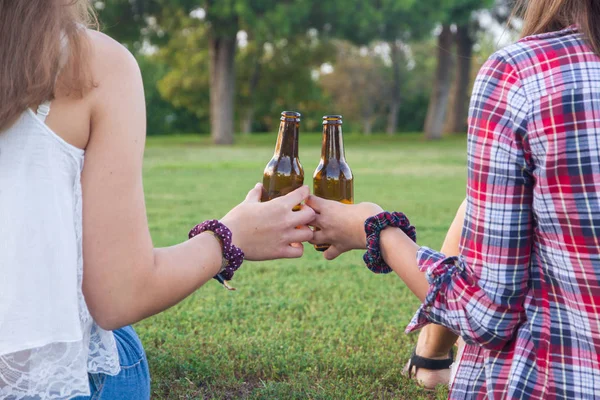 Female friends celebrating the holiday having a good time drinking beer in a park. — Stock Photo, Image