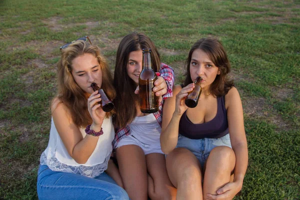 Kvinnliga vänner firar semester med en bra tid dricka öl i en park. De är glada. — Stockfoto