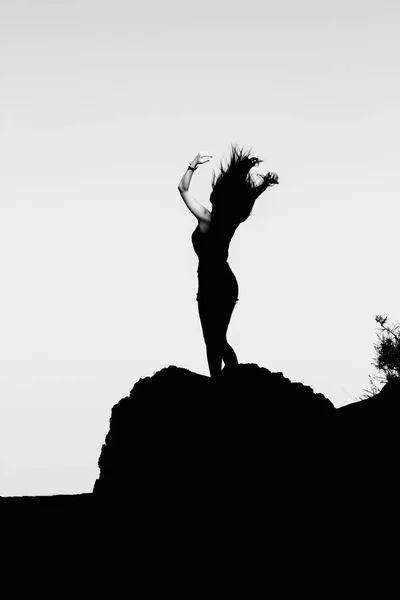 Silhouette of a girl on top of a mountain. — Stock Photo, Image