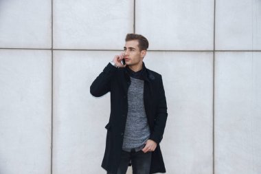 Bir akıllı telefon tutarak genç yakışıklı sarışın iş adamı. O telefonla konuşuyor.