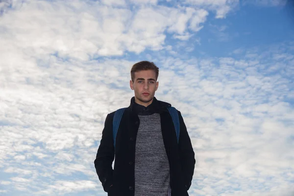 若い白い雲と青空を背景に青い目をした金髪の男. — ストック写真