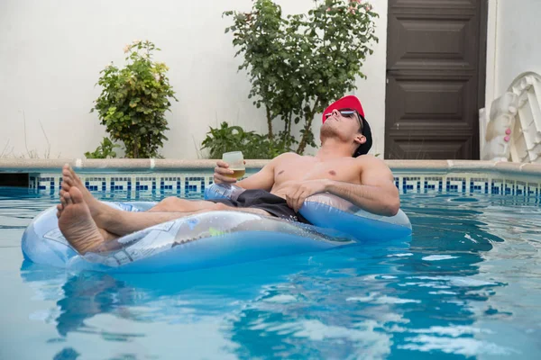 Güçlü delikanlı bir hava yatakta havuzda bira içmek
