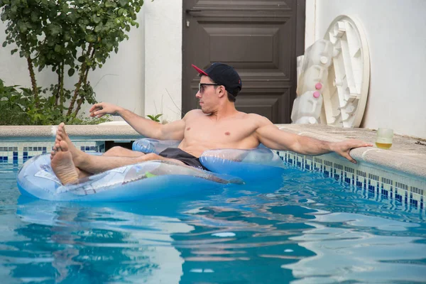 Güçlü delikanlı bir hava yatakta havuzda bira içmek