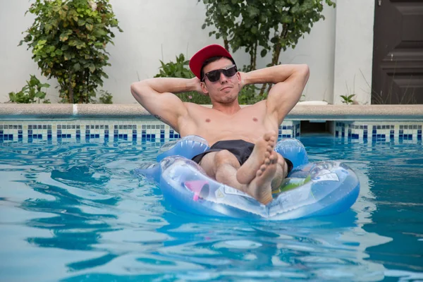 Hayattan zevk ve havuzun şişme bota banyo güçlü genç adam