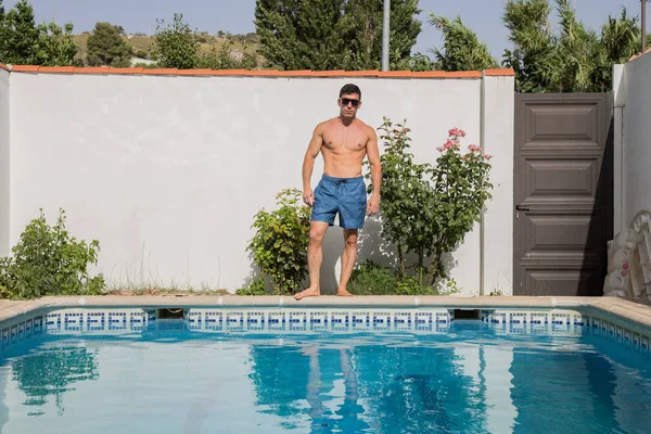Νέος ισχυρός άνδρας στην πισίνα σε μια ηλιόλουστη ημέρα. — Φωτογραφία Αρχείου