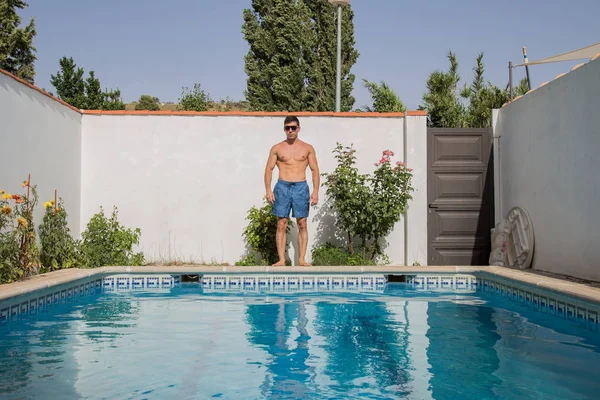 Güneşli bir havuzu üzerinde güçlü delikanlı.  