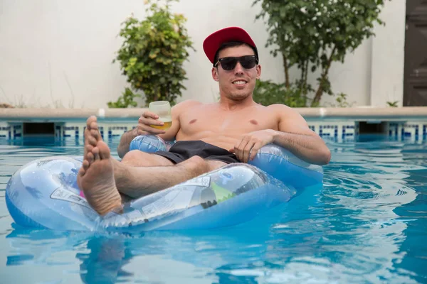 Güçlü delikanlı bir hava yatakta havuzda bira içmek