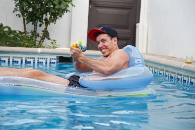 Su topu havuzu bulunan neşeli adam 