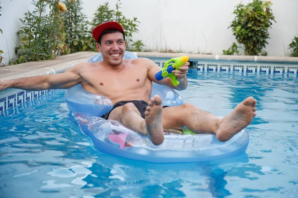 プールの水の銃で陽気な男 — ストック写真