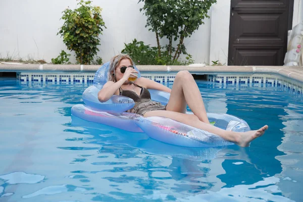 Jolie femme buvant de la bière dans la piscine — Photo