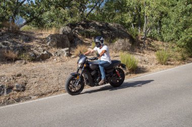 Adam dağlarda yolda bir motosiklet sürme