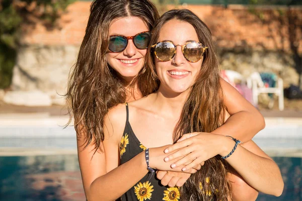 Chicas jóvenes posando felices en la piscina — Foto de Stock