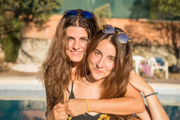 Chicas jóvenes posando felices en la piscina — Foto de Stock