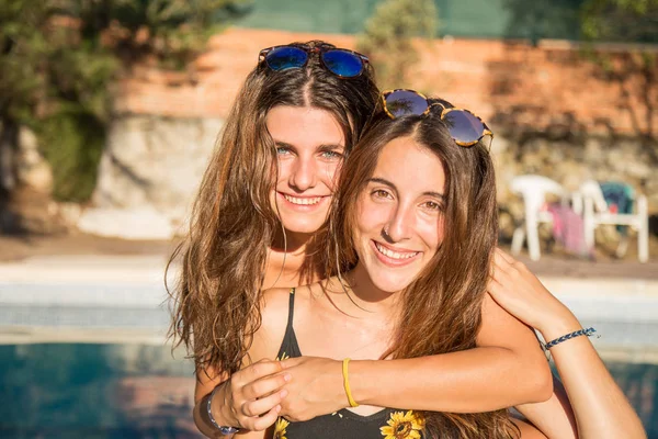Chicas jóvenes posando felices en la piscina — Foto de Stock