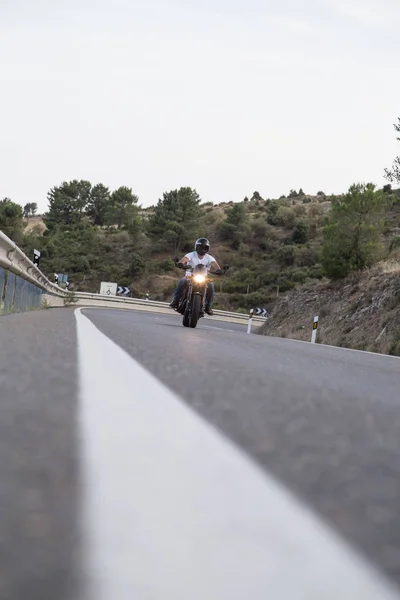 Homem montando uma motocicleta na estrada em montanhas — Fotografia de Stock