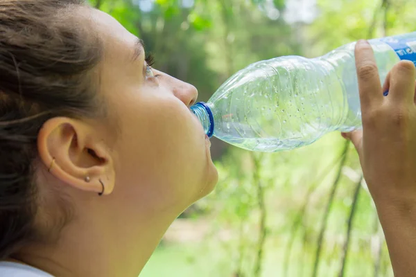 Женщина пьет воду в лесу — стоковое фото