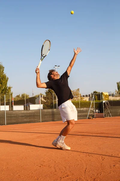 Człowiek podaniem piłki tenisowe — Zdjęcie stockowe