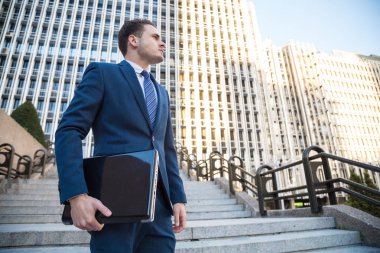 Elini uzak seyir içinde belgili tanımlık laptop ile poz şık elbiseli genç adam.