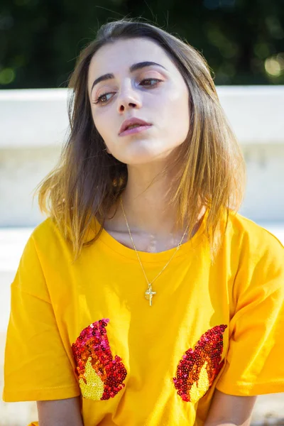 Молодая Женщина Позирует Улице Жёлтой Рубашке Пока Светит Солнце — стоковое фото