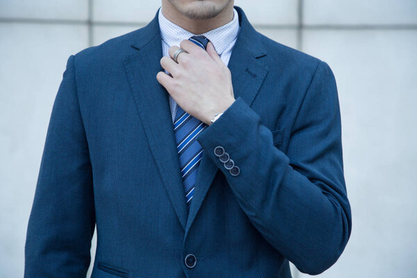 Young business man dressed in suit on a white background with lines of a building.