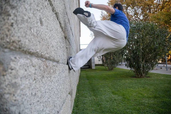 通りの壁にターンすることによって驚くほどのパルクール トリックをやって若い男 — ストック写真