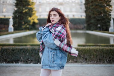 Denim ceket kameraya sensually Caddesi üzerinde seyir çekici genç kız. 