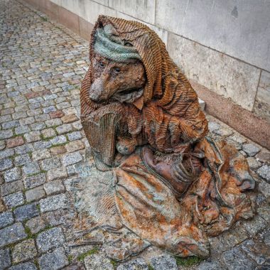 Heykel kaldırımda oturan evsiz fox gösteriyor. Stoc