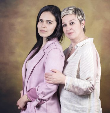 Sarı arka plan üzerinde closeup izole kamera, dikey, anne kızı yan yana bakarak.