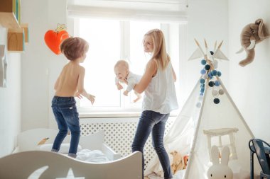 Parlak bir odada oynayan iki erkek çocuk annesi genç sarışın. Dışarıda güneşli bir gün. Kafkas ailesi birlikte vakit geçiriyor. Ağabeyim yatakta zıplıyor. Küçük kardeş annenin ellerinde. Arkadaş canlısı aile.