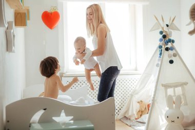 Parlak bir odada oynayan iki erkek çocuk annesi genç sarışın. Dışarıda güneşli bir gün. Kafkas ailesi birlikte vakit geçiriyor. Ağabeyim yatakta zıplıyor. Küçük kardeş annenin ellerinde. Arkadaş canlısı aile.