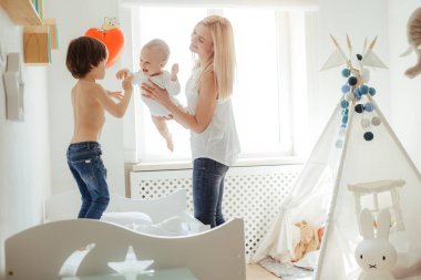 Parlak bir odada oynayan iki erkek çocuk annesi genç sarışın. Dışarıda güneşli bir gün. Kafkas ailesi birlikte vakit geçiriyor. Ağabeyim yatakta zıplıyor. Küçük kardeş annenin ellerinde. Arkadaş canlısı aile.