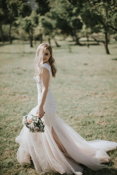 白いモダンなヒップスタードレスを歩いて結婚式の花嫁の肖像画 日没の森のヴィンテージのドレスで白人ブロンドの花嫁 魅力的な女性ポージングで花の花束 — ストック写真