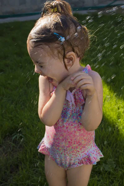 Linda chica está tomando una ducha al aire libre con expresión en la cara — Foto de Stock