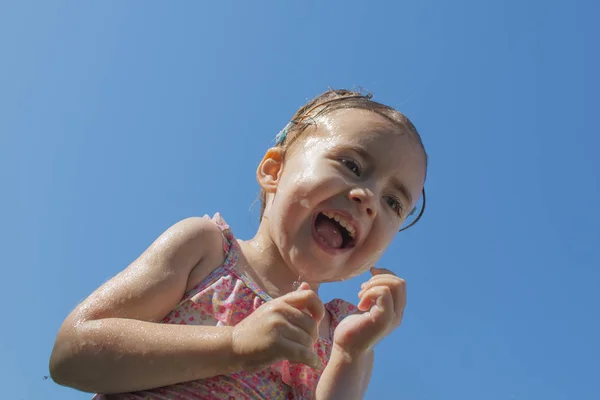 Retrato de una niña contra el cielo azul — Foto de Stock