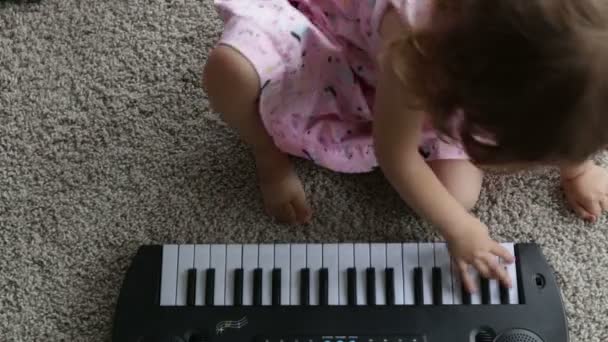 Niña jugando en un piano de juguete. Vídeo Full HD — Vídeo de stock