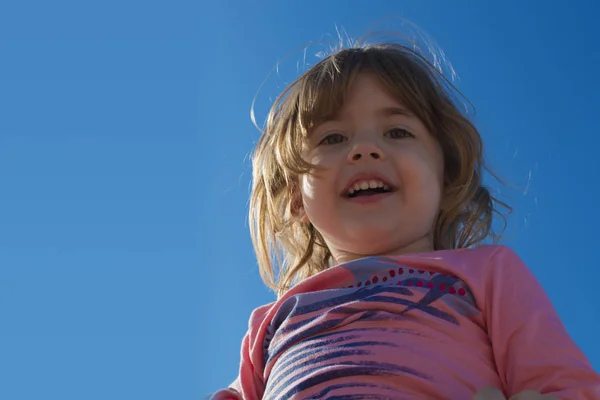 Riéndose niña en un fondo del cielo — Foto de Stock